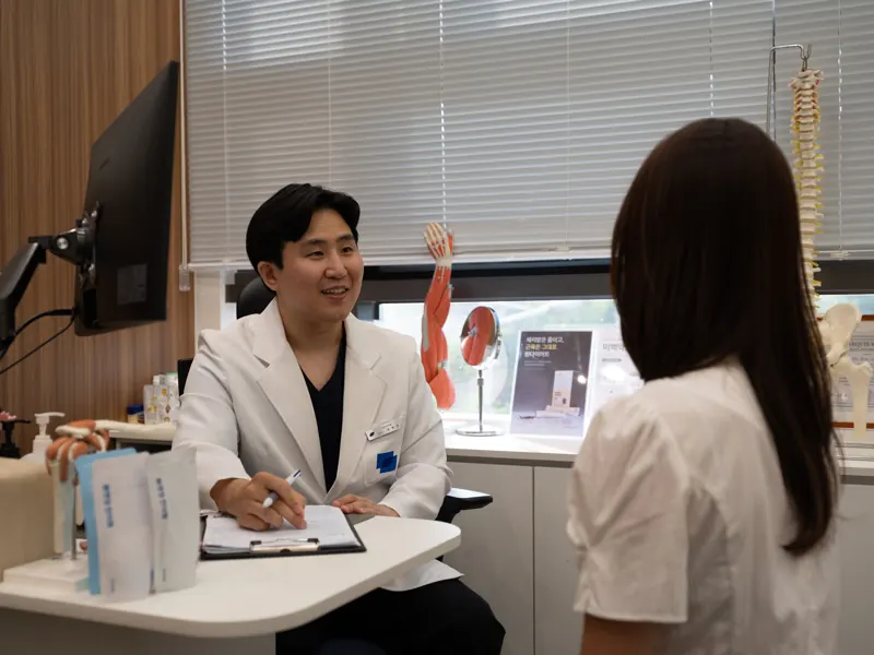 몸앤장한의원 진료실에서 원장이 환자와 상담하는 모습