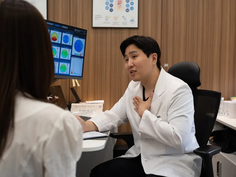 몸앤장한의원 진료실에서 원장이 환자에게 설명하는 모습