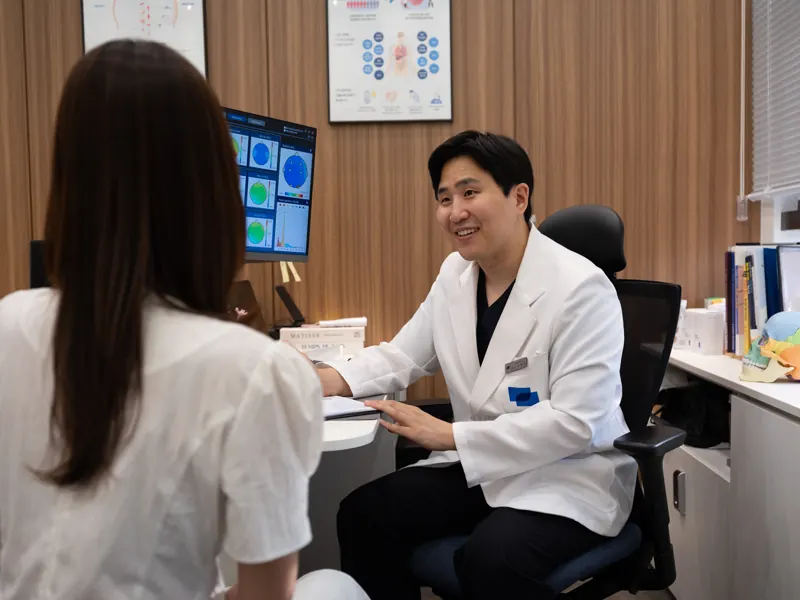 몸앤장한의원 진료실에서 원장이 환자와 상담하는 모습