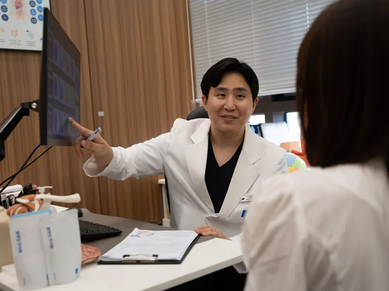 몸앤장한의원 진료실에서 원장이 모니터를 가리키며 설명하는 모습
