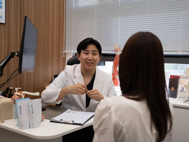 몸앤장한의원 진료실에서 원장이 환자의 이야기를 듣는 모습